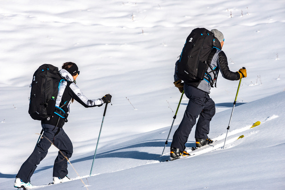 Two people cross-country skiing on a snowy landscape