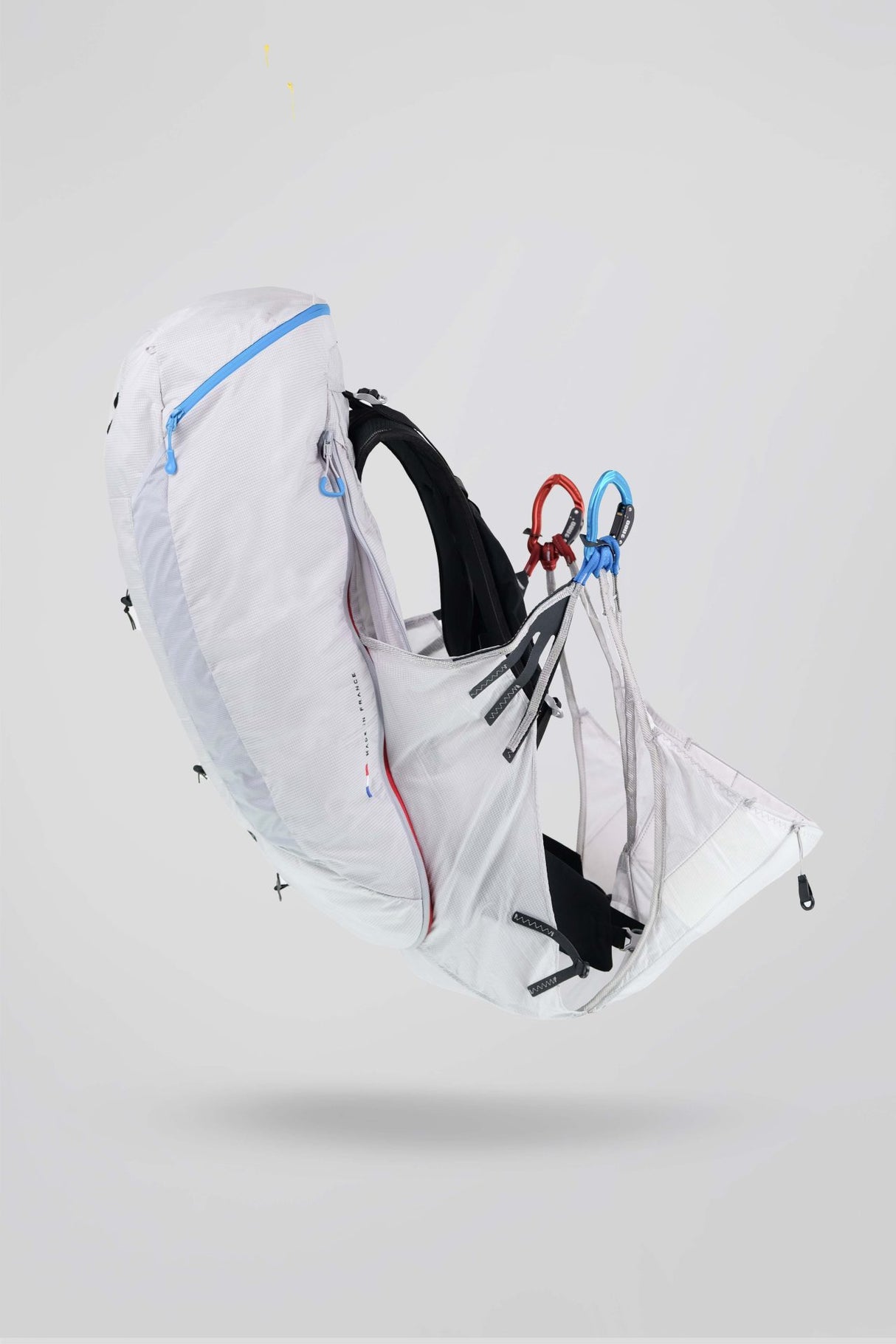 White backpack with black straps on a light gray background