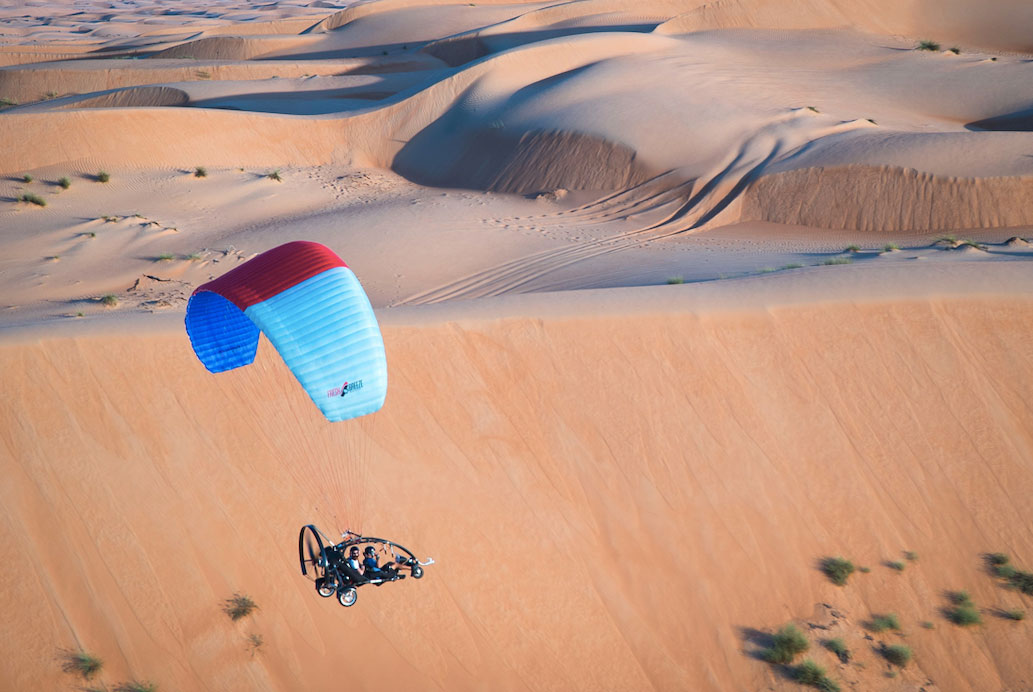Paratrike flying over desert
