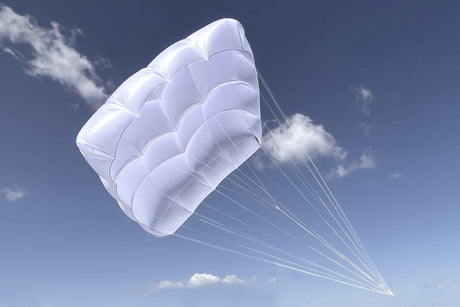 White parachute against a blue sky with clouds