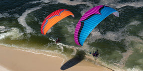 two parajets flying over the shore