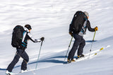Two people cross-country skiing on a snowy landscape