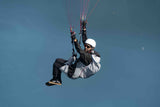 Person hand gliding against a clear blue sky