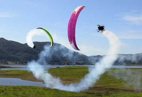 two men flying paramotors with flares