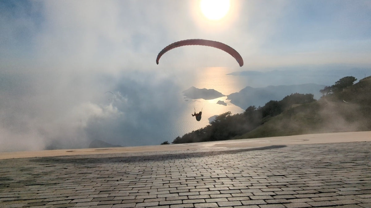 man paragliding in clouds
