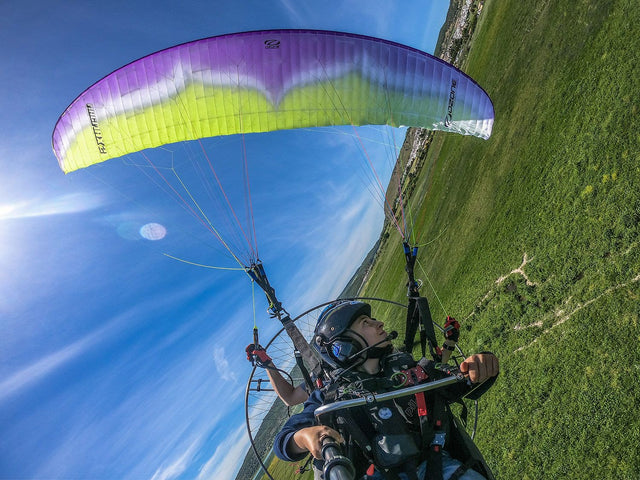 a selfie of two people flying a paramotor