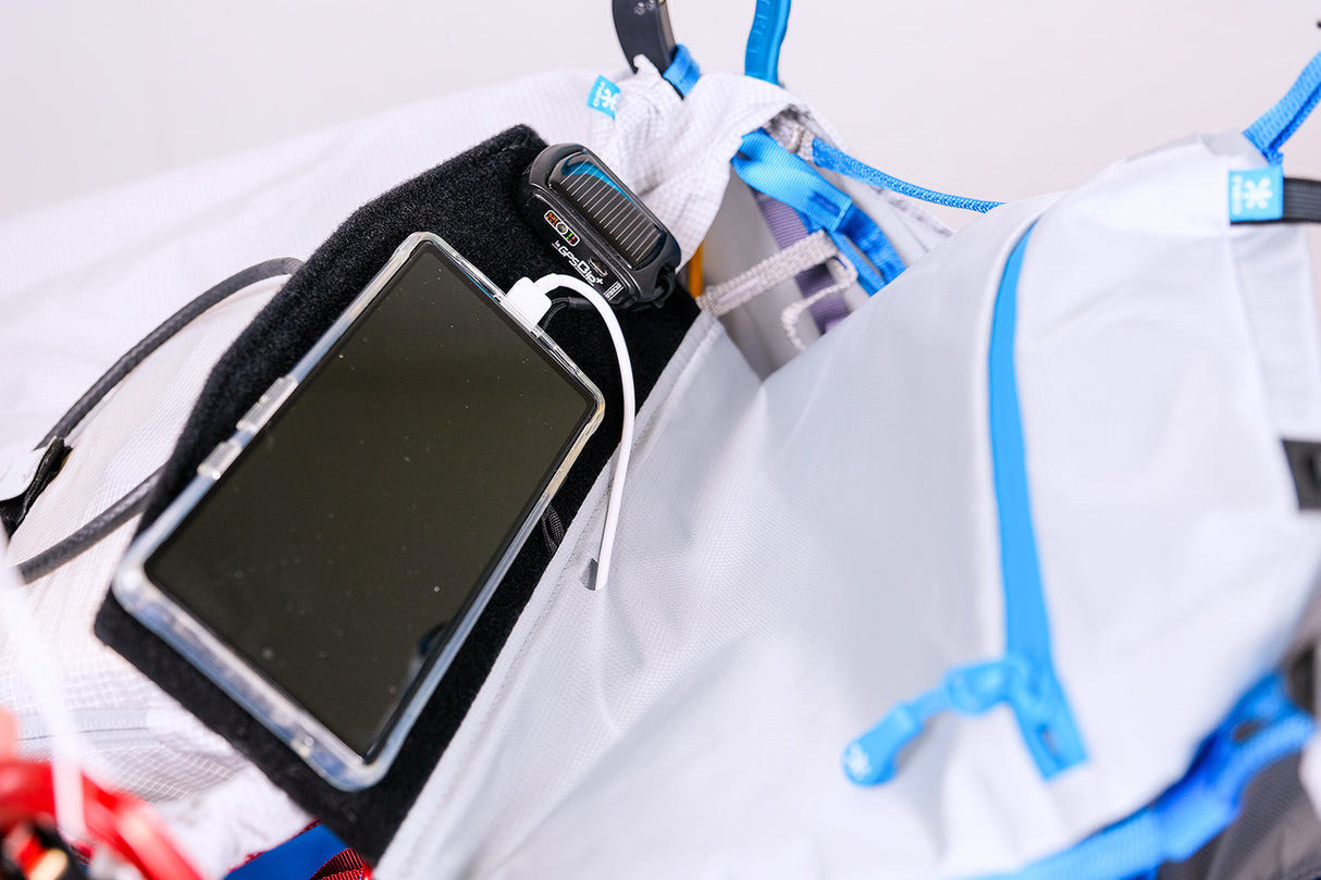 Phone case with screen protector and charging cable attached to a white bag.