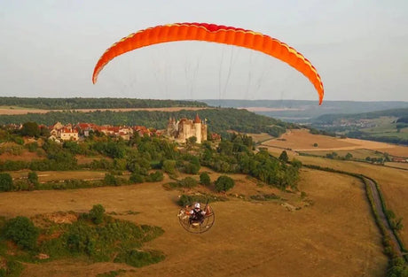 man flying paramotor near castle
