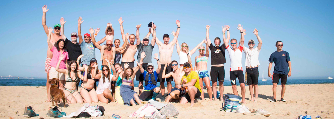 people in group on beach with hands in the air